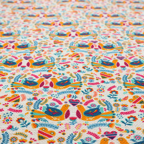 A Scandinavian folk art pattern. The design features symmetrical pairs of stylized teal and golden-yellow lovebirds facing each other under a small striped heart. They are surrounded by an intricate all-over arrangement of tiny multi-coloured wildflowers, hearts, and vines in shades of orange, magenta, yellow, and blue over a textured, off-white background.