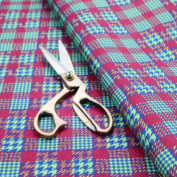 A dense, multi-coloured hounds tooth plaid pattern. The design features alternating blocks of bright magenta pink, electric royal blue, and neon lime green, interwoven into a structured, repetitive grid check with a classic textured twill appearance.