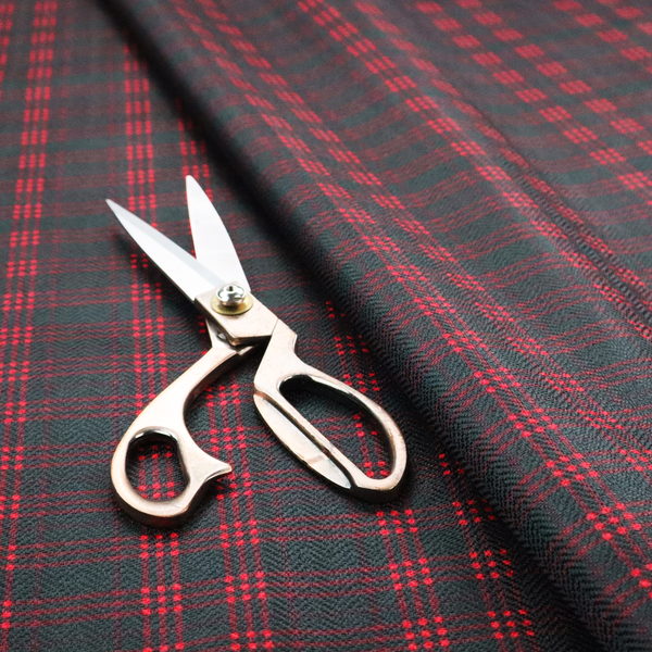 A classic, moody plaid pattern. The design is woven onto a dark charcoal grey background with a subtle, textured herringbone pattern, overlaid with a structured grid of thin, repeating intersecting lines in a bright, contrasting crimson red.