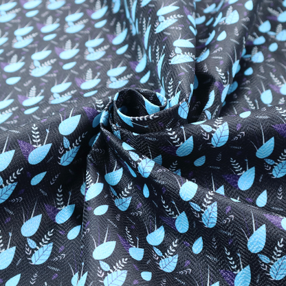 A dense, miniature botanical print. The design features small, light ice-blue teardrop shapes resembling abstract petals or water droplets, paired with tiny light blue textured leaves and white sprigs. The pattern is scattered over a dark charcoal grey background that features a subtle, woven herringbone texture.