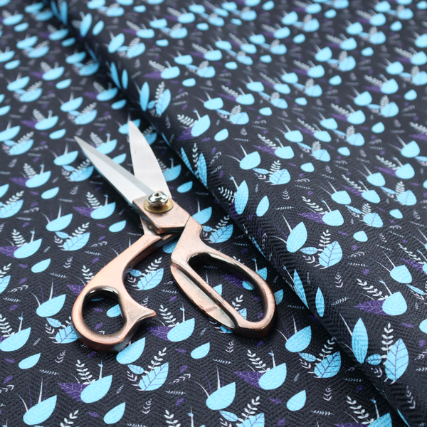 A dense, miniature botanical print. The design features small, light ice-blue teardrop shapes resembling abstract petals or water droplets, paired with tiny light blue textured leaves and white sprigs. The pattern is scattered over a dark charcoal grey background that features a subtle, woven herringbone texture.