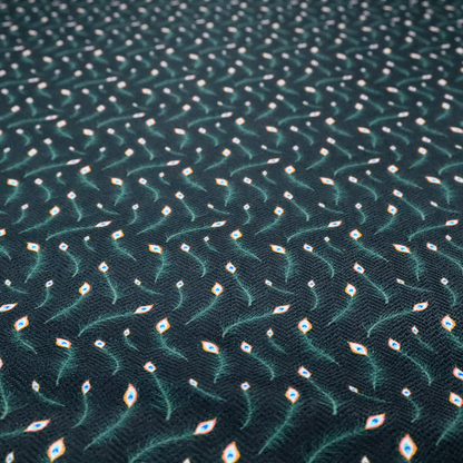 A dense, elegant peacock feather motif. The design showcase a repetitive pattern of small, curved green peacock feathers with bright orange, blue, and white "eyes" floating diagonally. The pattern is set against a dark charcoal grey background that has a subtle, woven herringbone texture.