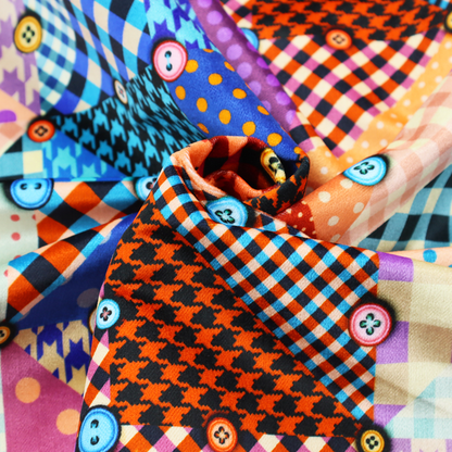 A vibrant, multi-coloured faux patchwork fabric pattern composed of alternating right-angled triangles to form a geometric grid. Each triangular patch features a distinct retro design, including hound's-tooth, gingham checks, diagonal plaids, and polka dots in various scales.