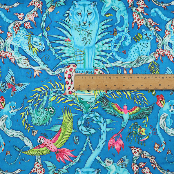 A vibrant turquoise blue fabric featuring an intricate, symmetrical maximalist print of a mythical tropical rainforest. Large, ethereal blue tigers with pink accents are flanked by dense fronds. The repeating pattern is filled with exotic jungle wildlife, including leopards, sloths hanging from vines, winged monkeys, bats, and colourful macaws in shades of bright pink and lime green.