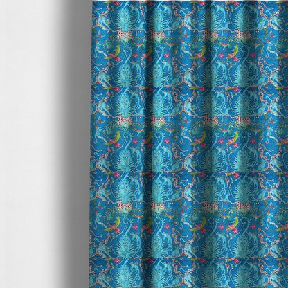 The fabric used to create these made-to-measure curtains is a vibrant turquoise blue fabric featuring an intricate, symmetrical maximalist print of a mythical tropical rainforest. Large, ethereal blue tigers with pink accents are flanked by dense fronds. The repeating pattern is filled with exotic jungle wildlife, including leopards, sloths hanging from vines, winged monkeys, bats, and colourful macaws in shades of bright pink and lime green.
