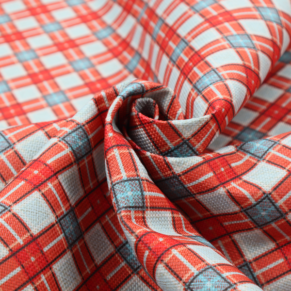 A vibrant diagonal plaid fabric pattern featuring crossing red, light blue, and white stripes on a textured background.