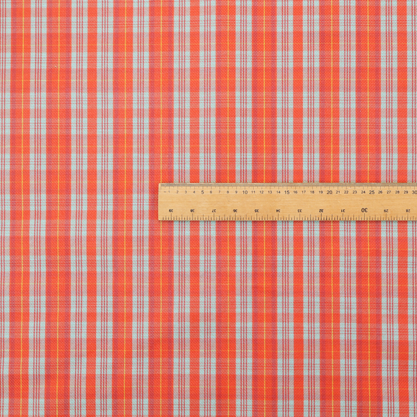A bright plaid fabric pattern featuring thin, intersecting stripes of orange, light teal, and yellow on a textured background.