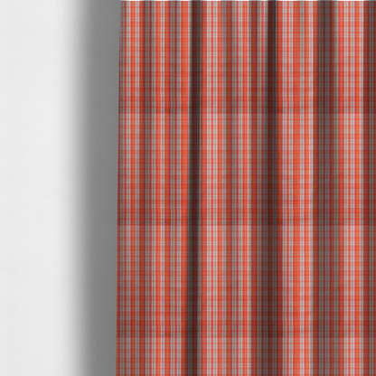 The fabric used to create these made-to-measure curtains is a bright plaid fabric pattern featuring thin, intersecting stripes of orange, light teal, and yellow on a textured background.