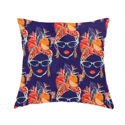 The fabric used to create this handmade cushion is a repeating pattern on dark purple fabric featuring stylized line-art faces of women wearing light green cat-eye sunglasses, bright red lipstick, and elaborate tropical headwraps adorned with orange slices and palm leaves.