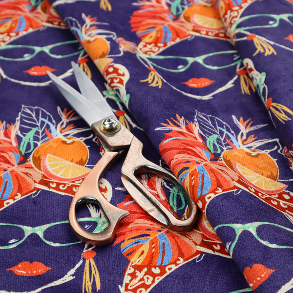 A repeating pattern on dark purple fabric featuring stylized line-art faces of women wearing light green cat-eye sunglasses, bright red lipstick, and elaborate tropical headwraps adorned with orange slices and palm leaves.
