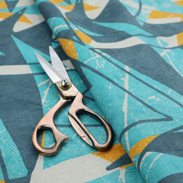 Fabric featuring a bold, retro geometric pattern with abstract, sharp arrow and shard shapes in turquoise, slate blue, mustard yellow, and white with a distressed texture.