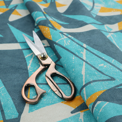Fabric featuring a bold, retro geometric pattern with abstract, sharp arrow and shard shapes in turquoise, slate blue, mustard yellow, and white with a distressed texture.