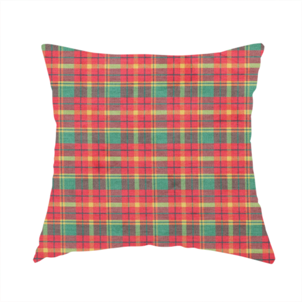 The fabric used to create this handmade cushion is a warm red and green plaid fabric pattern featuring a dense grid of intersecting yellow, dark green, and thin blue stripes.