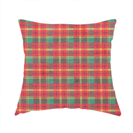 The fabric used to create this handmade cushion is a warm red and green plaid fabric pattern featuring a dense grid of intersecting yellow, dark green, and thin blue stripes.
