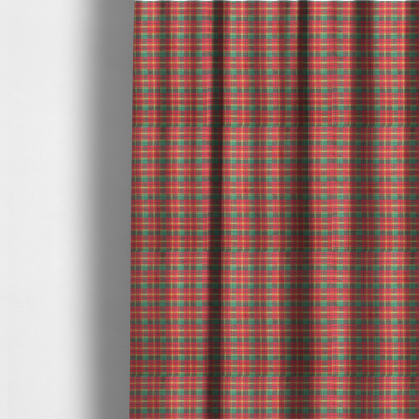 The fabric used to create these made-to-measure curtains is a warm red and green plaid fabric pattern featuring a dense grid of intersecting yellow, dark green, and thin blue stripes.