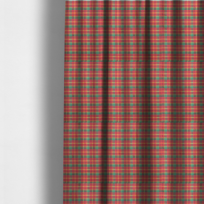 The fabric used to create these made-to-measure curtains is a warm red and green plaid fabric pattern featuring a dense grid of intersecting yellow, dark green, and thin blue stripes.