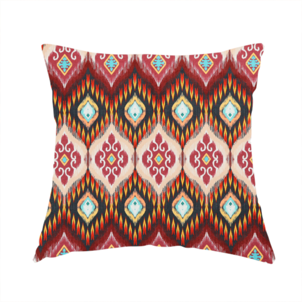The fabric used to create this handmade cushion is a vibrant, ornate ikat fabric pattern featuring rows of decorative diamond emblems, flame-like borders, and intricate scrollwork motifs in red, black, beige, and turquoise.
