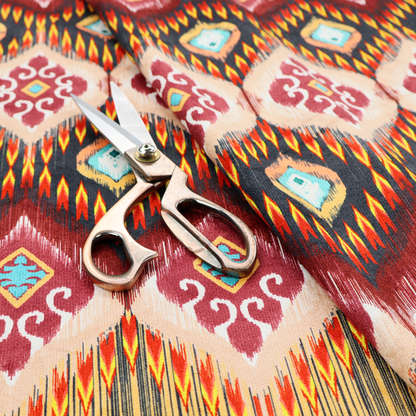 A vibrant, ornate ikat fabric pattern featuring rows of decorative diamond emblems, flame-like borders, and intricate scrollwork motifs in red, black, beige, and turquoise.