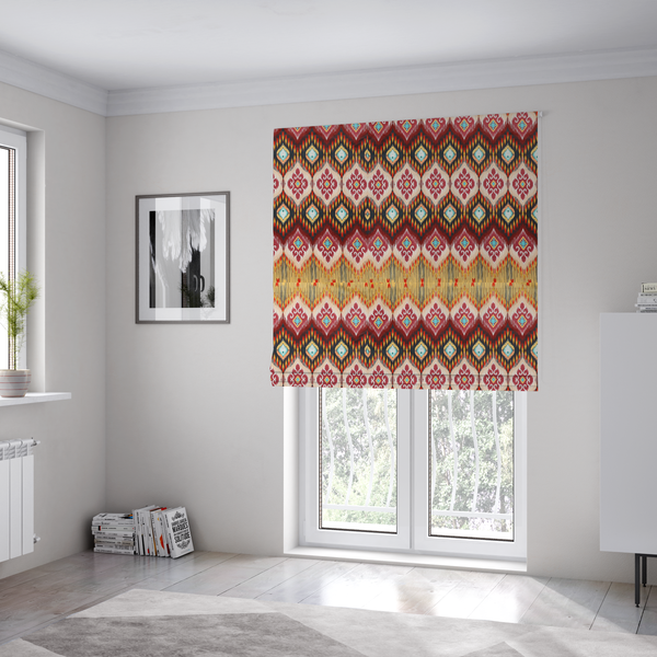 The fabric used to create these Roman blinds is a vibrant, ornate ikat fabric pattern featuring rows of decorative diamond emblems, flame-like borders, and intricate scrollwork motifs in red, black, beige, and turquoise.