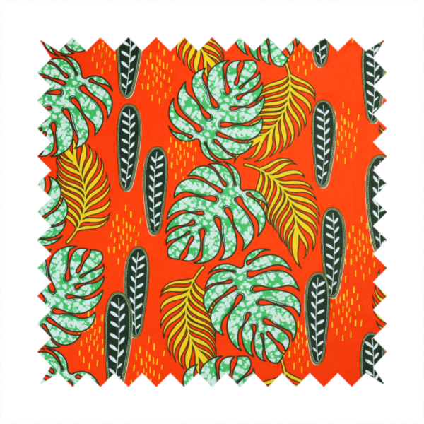 Fabric featuring a vibrant, repeating tropical pattern with textured green monstera leaves, yellow ferns, and dark green patterned seed pods on a bright orange background.
