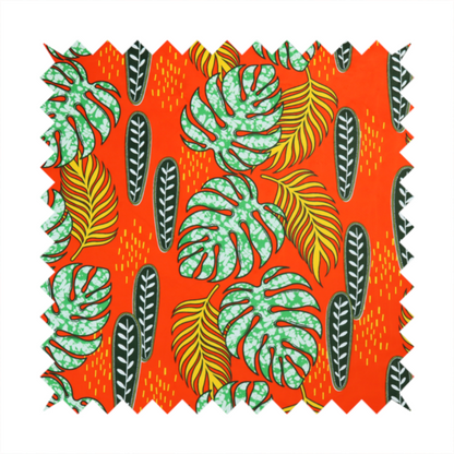 Fabric featuring a vibrant, repeating tropical pattern with textured green monstera leaves, yellow ferns, and dark green patterned seed pods on a bright orange background.