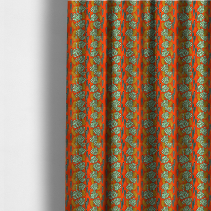 The fabric used to create these made-to-measure curtains features a vibrant, repeating tropical pattern with textured green monstera leaves, yellow ferns, and dark green patterned seed pods on a bright orange background.