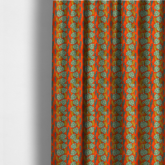 The fabric used to create these made-to-measure curtains features a vibrant, repeating tropical pattern with textured green monstera leaves, yellow ferns, and dark green patterned seed pods on a bright orange background.