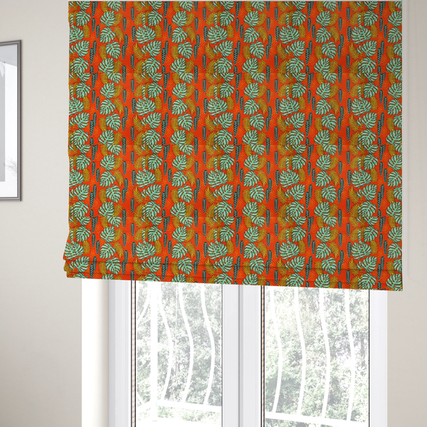 The fabric used to create these Roman blinds features a vibrant, repeating tropical pattern with textured green monstera leaves, yellow ferns, and dark green patterned seed pods on a bright orange background.