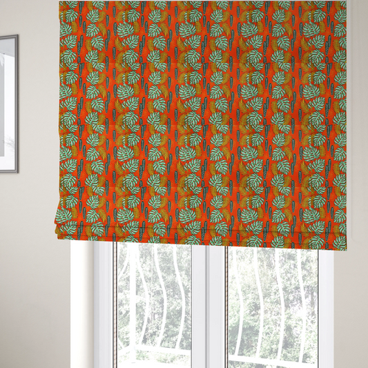 The fabric used to create these Roman blinds features a vibrant, repeating tropical pattern with textured green monstera leaves, yellow ferns, and dark green patterned seed pods on a bright orange background.