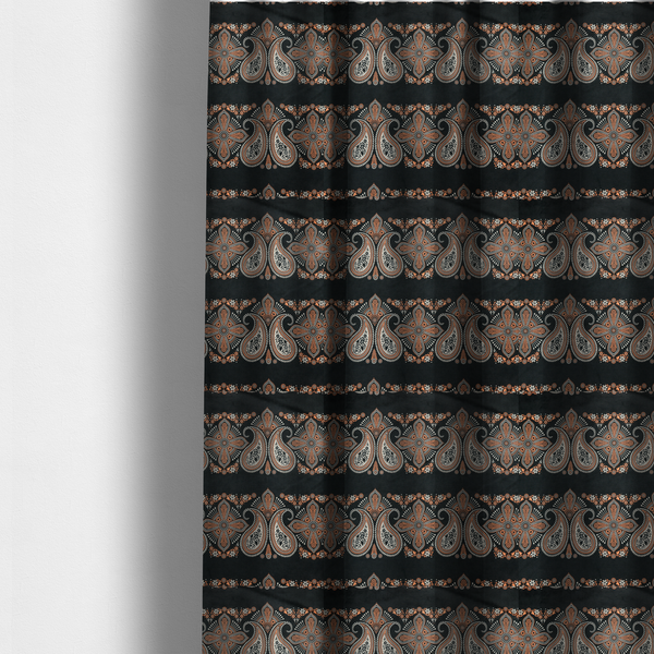 The fabric used to create these made-to-measure curtains is a black fabric pattern featuring elegant horizontal bands of intricate paisley motifs and ornate cross-shaped designs in cream and terracotta orange.