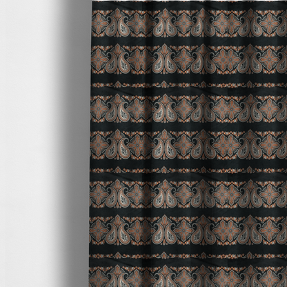 The fabric used to create these made-to-measure curtains is a black fabric pattern featuring elegant horizontal bands of intricate paisley motifs and ornate cross-shaped designs in cream and terracotta orange.