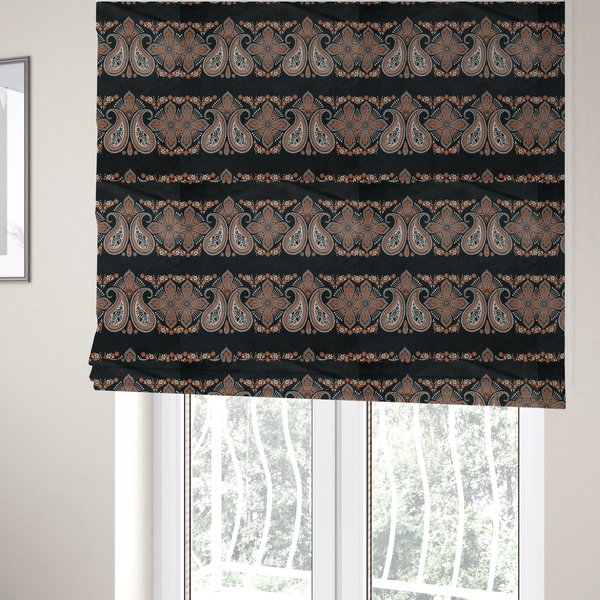 The fabric used to create these Roman blinds is a black fabric pattern featuring elegant horizontal bands of intricate paisley motifs and ornate cross-shaped designs in cream and terracotta orange.