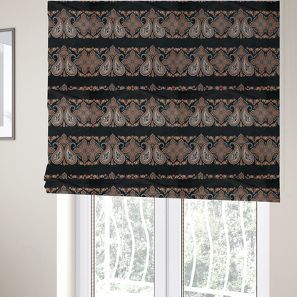 The fabric used to create these Roman blinds is a black fabric pattern featuring elegant horizontal bands of intricate paisley motifs and ornate cross-shaped designs in cream and terracotta orange.