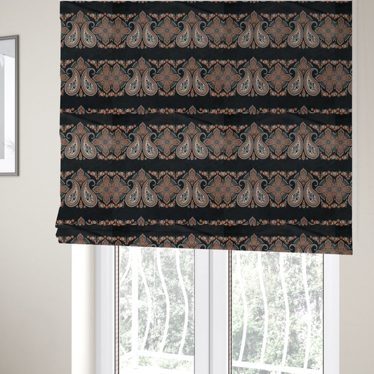 The fabric used to create these Roman blinds is a black fabric pattern featuring elegant horizontal bands of intricate paisley motifs and ornate cross-shaped designs in cream and terracotta orange.