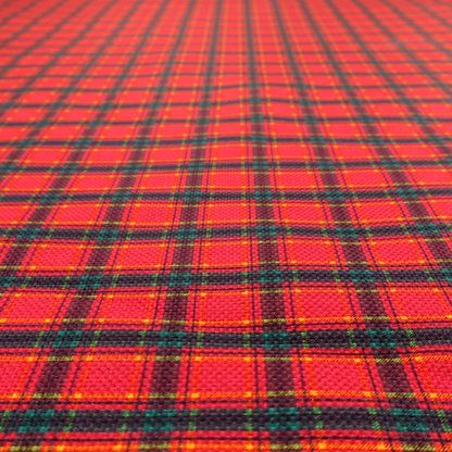 A vibrant red plaid fabric pattern featuring a dense grid of intersecting dark green and thin yellow stripes.