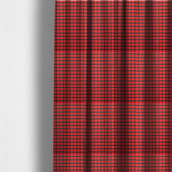 The fabric used to create these made-to-measure curtains is a vibrant red plaid fabric pattern featuring a dense grid of intersecting dark green and thin yellow stripes.