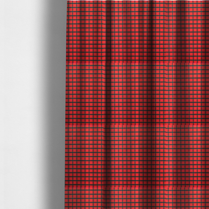 The fabric used to create these made-to-measure curtains is a vibrant red plaid fabric pattern featuring a dense grid of intersecting dark green and thin yellow stripes.