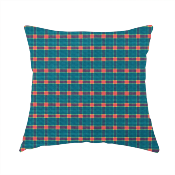 The fabric used to create this handmade cushion is a rich teal plaid fabric pattern featuring a dense grid of intersecting dark blue and thin yellow stripes with bright red square accents.