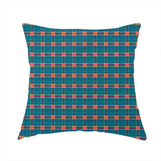 The fabric used to create this handmade cushion is a rich teal plaid fabric pattern featuring a dense grid of intersecting dark blue and thin yellow stripes with bright red square accents.