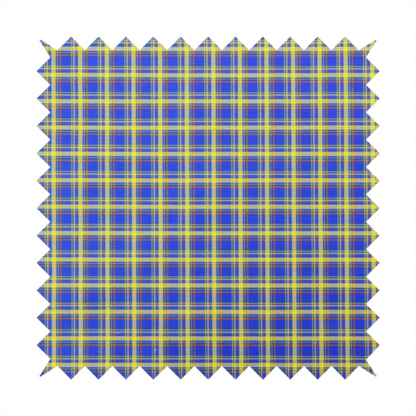 A bright blue plaid fabric pattern featuring a tight, repeating grid of intersecting yellow stripes and thin orange accent lines.