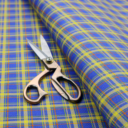 A bright blue plaid fabric pattern featuring a tight, repeating grid of intersecting yellow stripes and thin orange accent lines.
