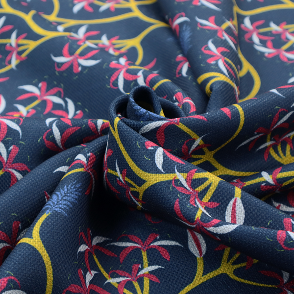 A deep blue fabric pattern featuring a winding trail of bright yellow vines accented with clusters of pink and white flowers and blue fern leaves.