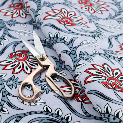 An ornate, traditional Kalamkari-style pattern of swirling grey vines and large lotus-like flowers with red and white petals on a light grey background.