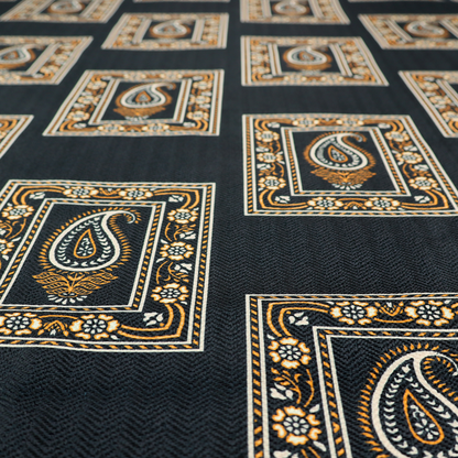 Fabric featuring a traditional repeating pattern of detailed white and gold paisley motifs, each enclosed within an ornate rectangular border on a charcoal black background.