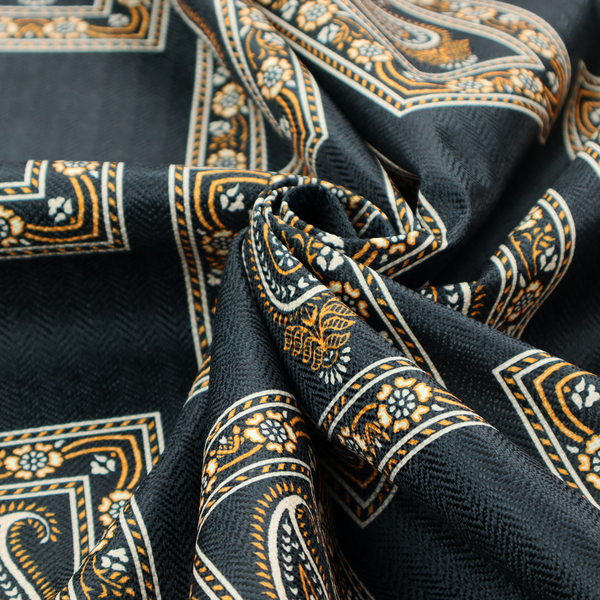 Fabric featuring a traditional repeating pattern of detailed white and gold paisley motifs, each enclosed within an ornate rectangular border on a charcoal black background.