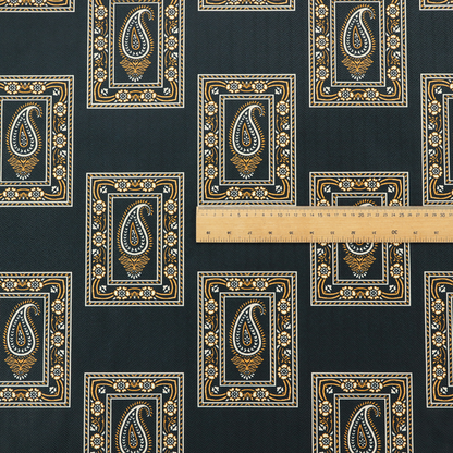 Fabric featuring a traditional repeating pattern of detailed white and gold paisley motifs, each enclosed within an ornate rectangular border on a charcoal black background.