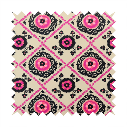 Fabric featuring a vibrant bohemian Suzani-style pattern with bold hot pink and black floral medallions arranged in a diamond lattice on a cream background.