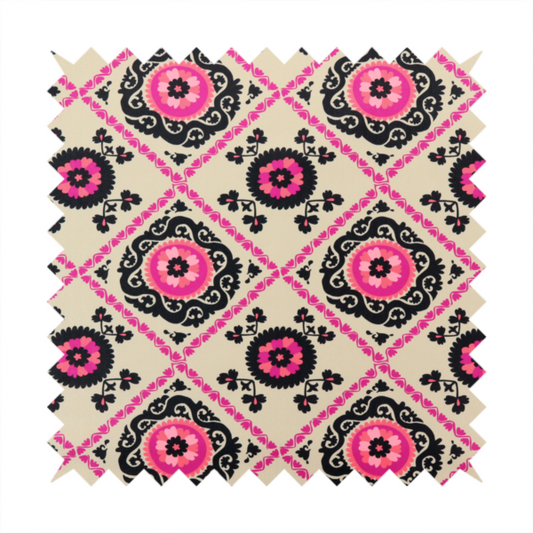Fabric featuring a vibrant bohemian Suzani-style pattern with bold hot pink and black floral medallions arranged in a diamond lattice on a cream background.