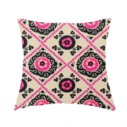 The fabric used to create this handmade cushion is a featuring a vibrant bohemian Suzani-style pattern with bold hot pink and black floral medallions arranged in a diamond lattice on a cream background.