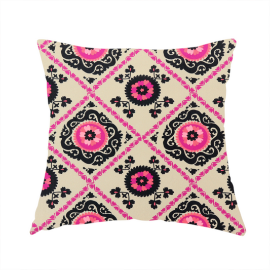 The fabric used to create this handmade cushion is a featuring a vibrant bohemian Suzani-style pattern with bold hot pink and black floral medallions arranged in a diamond lattice on a cream background.
